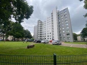 a large white building with cars parked in a park at 1 A Ferienwohnung Modern Duisburg in Duisburg