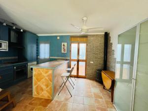 a kitchen with blue walls and a counter with chairs at IslaOC Apartamentos - Adosado Villaparaiso in Isla Cristina