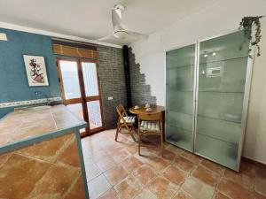 a kitchen with a table and a glass shower at IslaOC Apartamentos - Adosado Villaparaiso in Isla Cristina