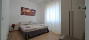 a small bedroom with a bed and a window at Mozart Haus camere in Quartu SantʼElena