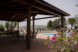 a patio with chairs and a table and a pool at Agriturismo Bellajo - Ville Rustiche con Piscina in Agrigento