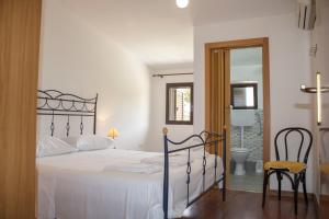 a bedroom with a bed and a chair and a mirror at Agriturismo Bellajo - Ville Rustiche con Piscina in Agrigento +129 photos