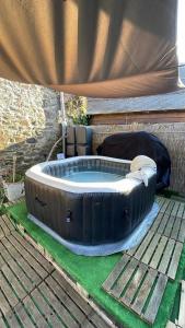a hot tub sitting on top of a deck at LE COCON de MATIGNON Gîte 4 étoiles 5 kms mer in Matignon