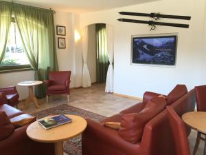 a living room with a couch and chairs and tables at RTA Torre Del Brenta in Madonna di Campiglio