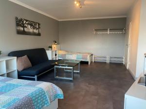 a room with a bed and a couch and a table at 1 A Ferienwohnung Modern Duisburg in Duisburg
