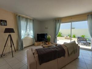 a living room with a couch and a television at Pré-Rochet in Saint-Jean-de-Monts