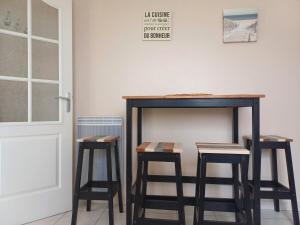 a table and two stools in front of a wall at Pré-Rochet in Saint-Jean-de-Monts +4 photos