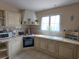 a kitchen with a stove and a sink and a microwave at Pré-Rochet in Saint-Jean-de-Monts