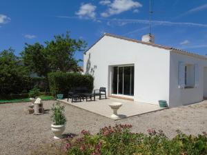 a white house with a patio in a garden at Pré-Rochet in Saint-Jean-de-Monts