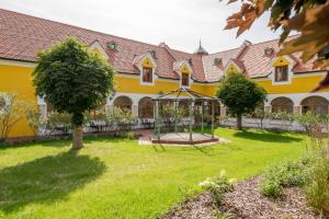 żółty dom z ogrodem i altaną w obiekcie Hotel Römerstein w mieście Loipersdorf bei Fürstenfeld