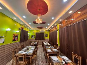 a dining room with wooden tables and a chandelier at Dee Dash Inn in Bhubaneshwar