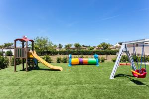 a playground with two swings and a slide at La Pineta Residence in Otranto