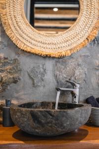 une salle de bain avec un lavabo en pierre et un miroir dans l'établissement Villa Sea Walk Mykonos 200m to ftelia beach, à Mykonos