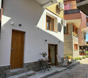a white building with a wooden door and a table at Casa Mint in Sozopol