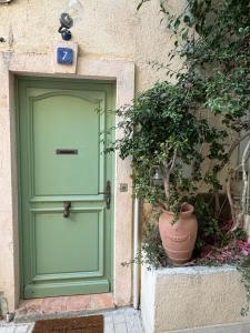 eine grüne Tür und eine Topfpflanze neben einem Gebäude in der Unterkunft Maison Saint Tropez in Saint-Tropez