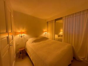 ein Schlafzimmer mit einem weißen Bett und einem Fenster in der Unterkunft Maison Saint Tropez in Saint-Tropez