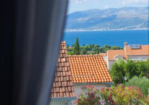 a view from a window of a town with roofs at ꕥ Apartments Residence SUNCE Supetar, Family choice - cozy base to stay and explore island Brac FREE PARKING in Supetar