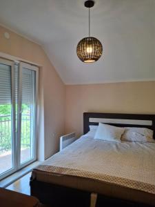 a bedroom with a bed and a pendant light at Anzoli 1 in Nikšić