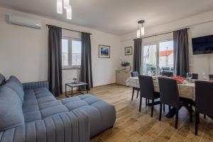 a living room with a blue couch and a table at Villa Milutin 1 in Vrsi