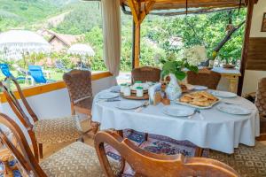 una sala da pranzo con un tavolo con del cibo sopra di Дановатъ къща a Zgorigrad