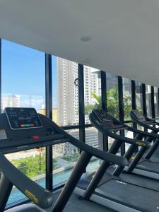 eine Reihe von Laufbändern in einem Fitnessraum mit einem großen Fenster in der Unterkunft 2 Carpark 3R2B 12 Pax City View Condominium 23A in Jelutong