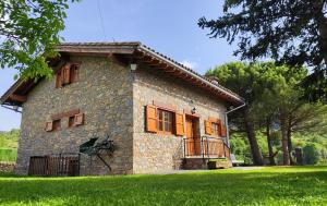 Una gran casa de piedra con un balcón en el césped en Cal Pujol by Rural House, en Toloríu