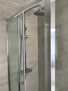 a shower with a glass door in a bathroom at Amazing Cambridge house in Chesterton
