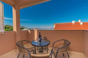 a table and chairs on a balcony with a view at Polina Apartmani in Klenovica