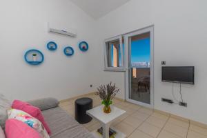 a living room with a couch and a tv at Polina Apartmani in Klenovica
