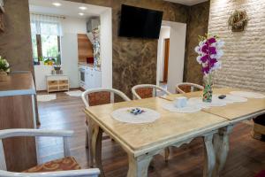una sala da pranzo con tavolo in legno e fiori di Дановатъ къща a Zgorigrad