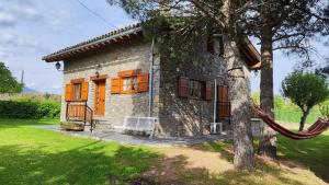 una casa de piedra con una hamaca delante de ella en Cal Pujol by Rural House, en Toloríu