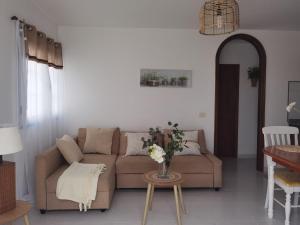 a living room with a couch and a table at Atardecer in La Santa