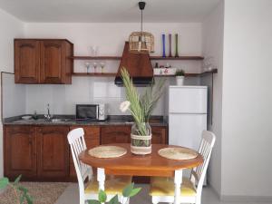 a kitchen with a table with a vase of flowers on it at Atardecer in La Santa