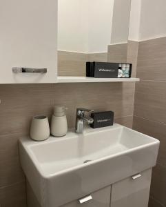a white sink in a bathroom with a shelf at Mavino Apartment Zagreb in Zagreb +12 photos