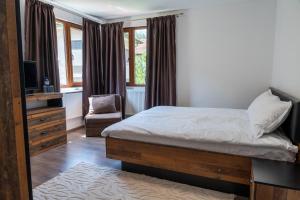 una camera con letto, TV e sedia di Дановатъ къща a Zgorigrad Altre 97 foto