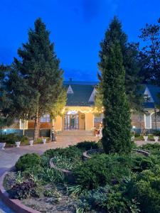 a building with two trees in a yard at night at Radugawest2 in Koshkolʼ