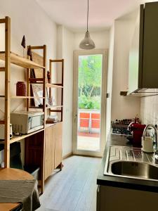a kitchen with a sink and a door to a patio at TERRAZZA SUL GIARDINO - Vaticano e Stadio Olimpico in Rome