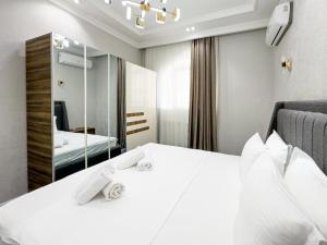 a hotel room with a bed and a mirror at YakkaSaray Premium Apartment in Tashkent