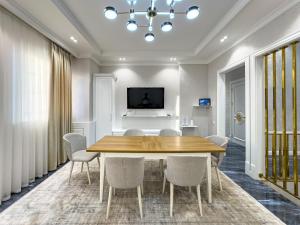 a dining room with a wooden table and chairs at YakkaSaray Premium Apartment in Tashkent