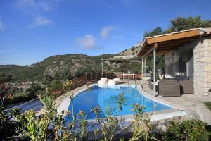 a swimming pool with chairs and a house at Panorama Villas in Drymon