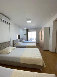 a bedroom with three beds and a large window at Home DINA in Ilidža