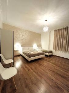 a bedroom with a bed and a couch and a chair at EFFE Home in Catania