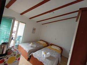 a room with two beds and a window at Rooftop rooms Ohrid in Ohrid