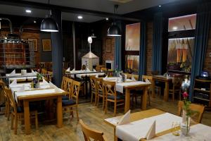 ein Restaurant mit Tischen und Stühlen in einem Raum in der Unterkunft Hotel Rad in Graudenz