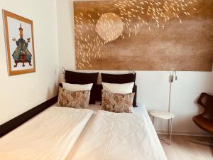 a bedroom with a bed and a painting on the wall at City Hotel Nattergalen in Odense