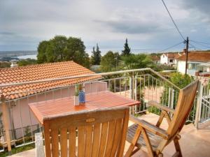 a table and chairs on a balcony with a house at Appartement Caspar- Turm Krk in Sveti Vid-Miholjice