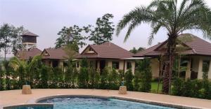 a house with a swimming pool in front of it at Dachatorn Village in Khao Lak