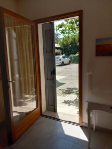 een open glazen deur met zicht op een auto bij casa vacanze cedro in San Lazzaro di Savena +6 foto's