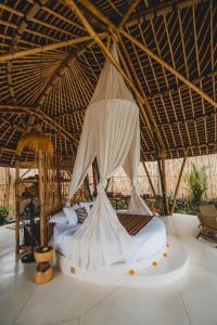 a bed in a room with a net at Nivriti Bali in Sidemen +102 photos