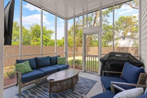 a screened in porch with a blue couch and chairs at Time Flys - 498 Baisden Lane in Mallory Park